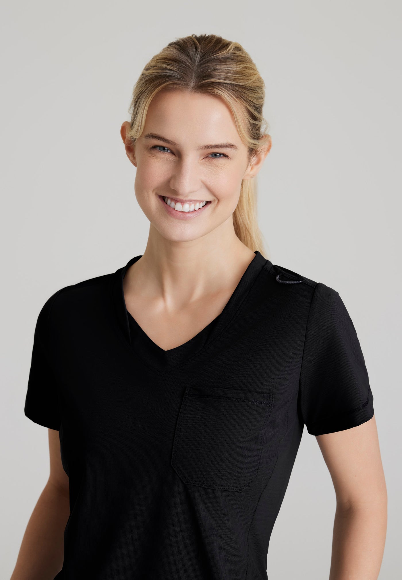 SKT221 Skechers Slip-Ins scrub top in black. tuckable. one top pocket. women's scrub uniforms. stretchable fabric. close up image