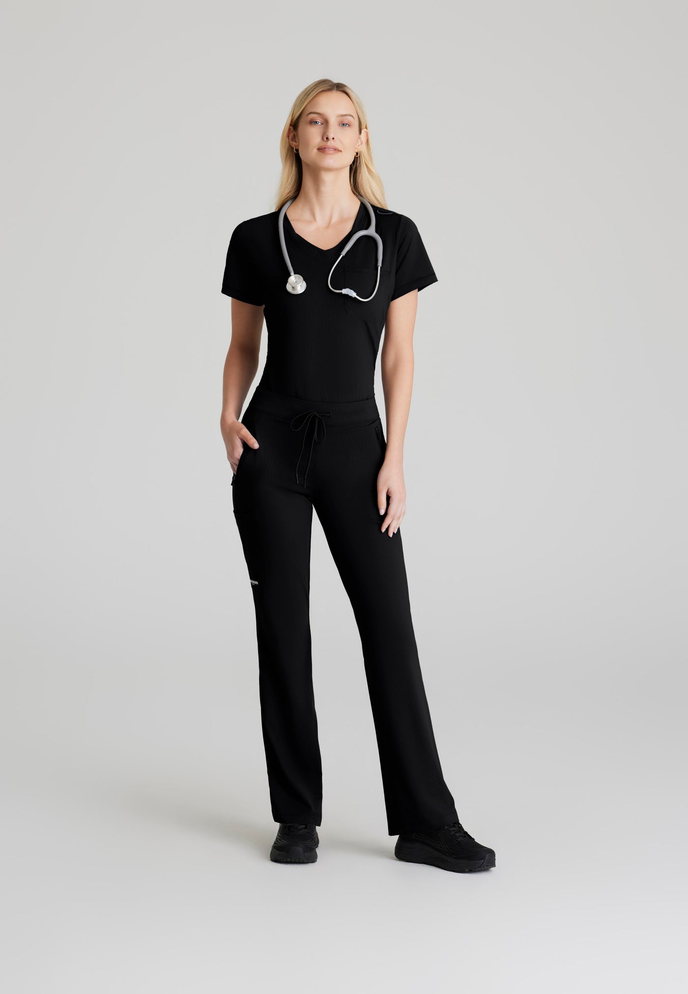 SKT221 Skechers Slip-Ins scrub top in black. tuckable. one top pocket. women's scrub uniforms. stretchable fabric. full body image