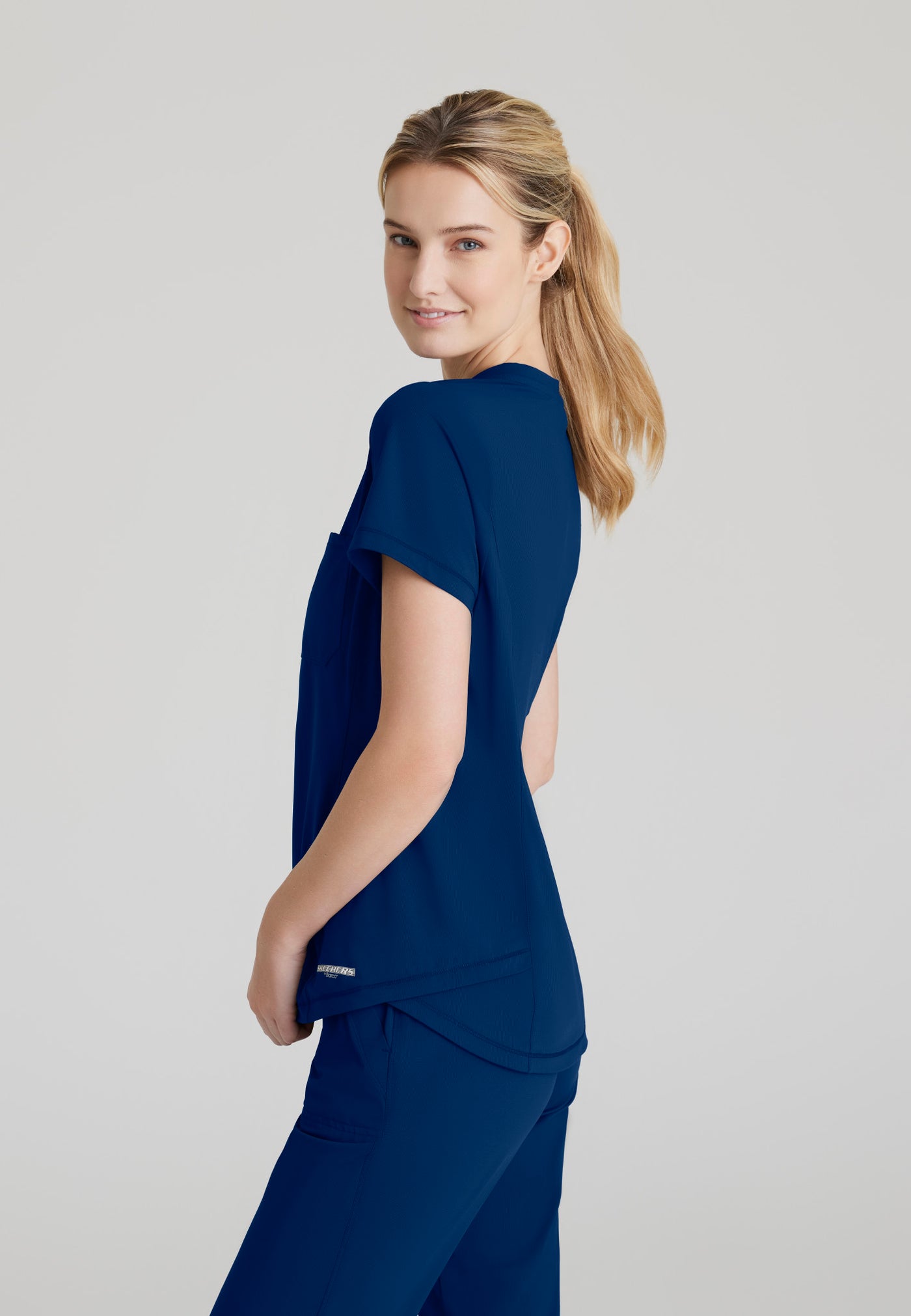 SKT221 Skechers Slip-Ins scrub top in navy. tuckable. one top pocket. women's. stretchable fabric. side image