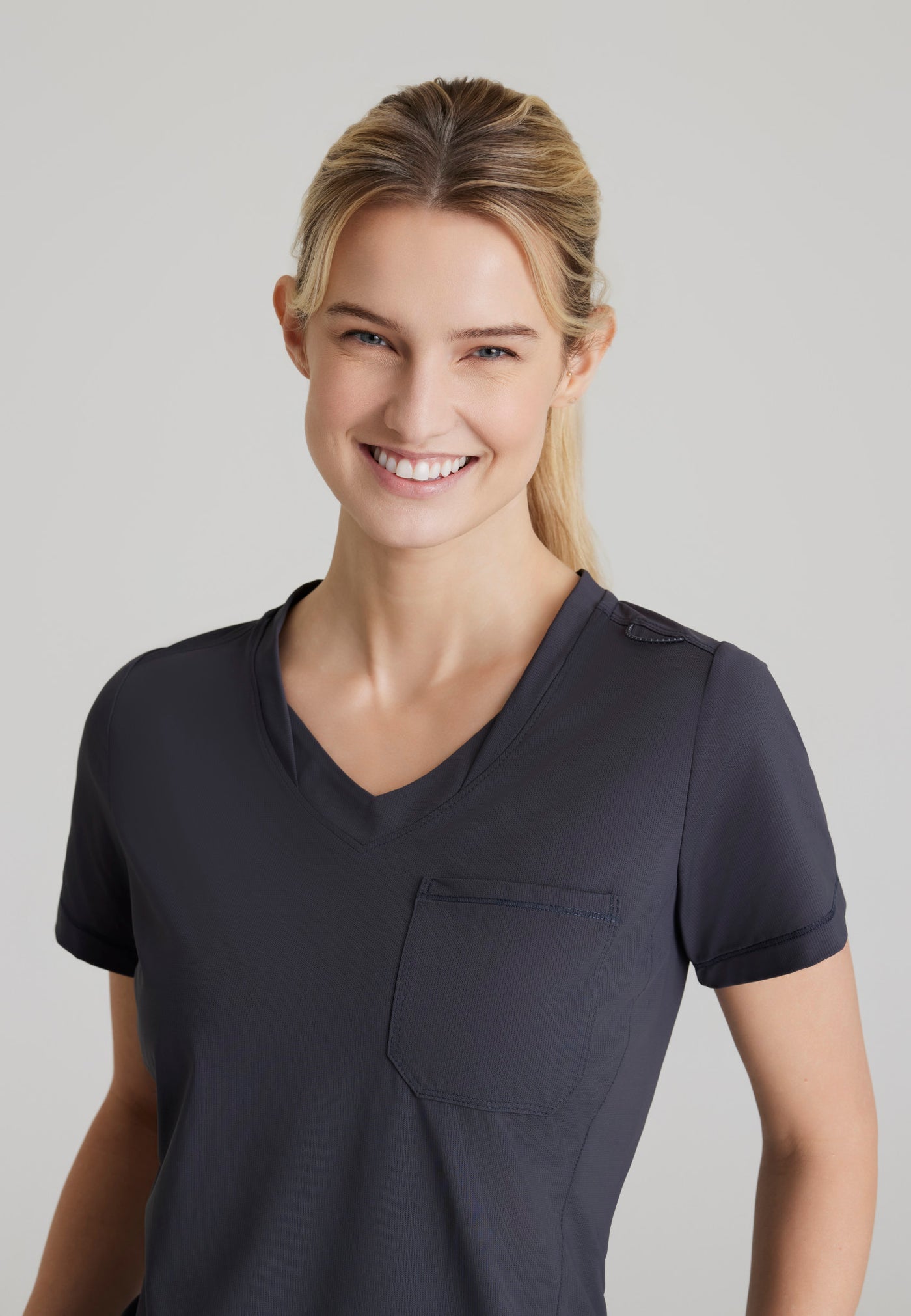 SKT221 Skechers Slip-Ins scrub top in pewter. tuckable. one top pocket. women's. stretchable fabric. close up image